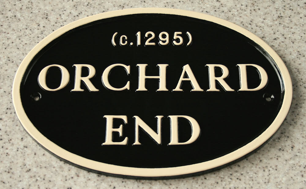 black oval metal plaque with magnolia text & border
